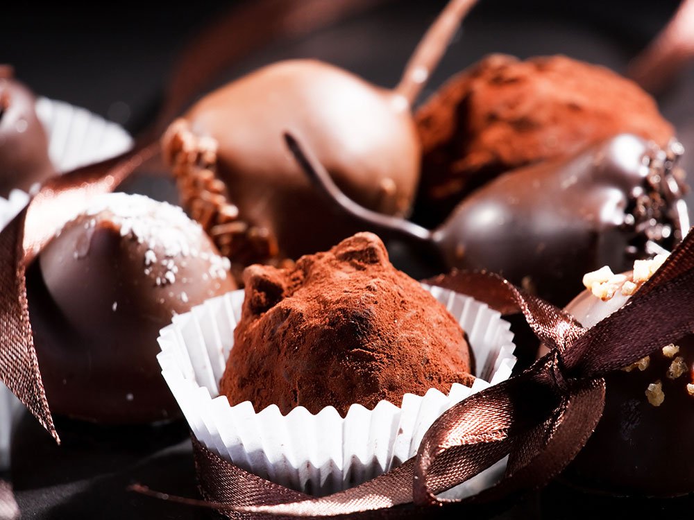 An assortment of chocolate truffles in paper cups, decorated with brown ribbons, perfect for day trips near Willamette Valley.